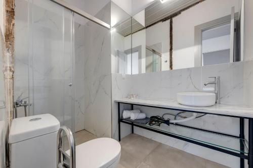 埃尔莫波利斯The Ten Syros的白色的浴室设有水槽和卫生间。