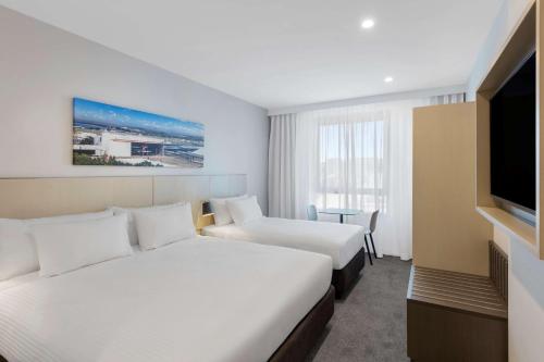 悉尼悉尼机场旅客之家酒店的酒店客房设有两张床和一台平面电视。