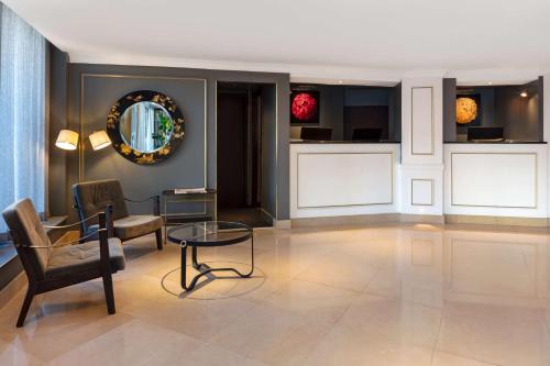 伦敦Radisson Blu Edwardian Bond Street Hotel, London的客厅配有椅子和桌子