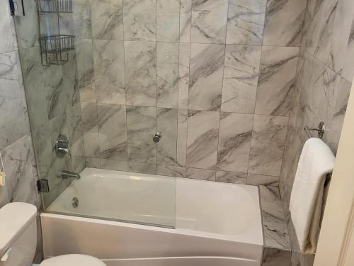 PriorySoleil Deluxe Hartland Home的浴室配有白色浴缸和卫生间。