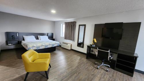 KewaneeMotel 6-Kewanee, IL的酒店客房,配有床和黄色椅子