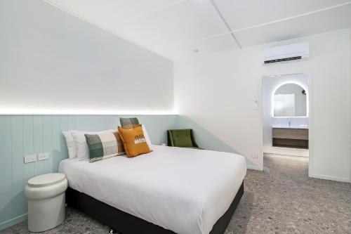 麦凯Bel Air Motel的一间带白色大床的卧室和一间浴室