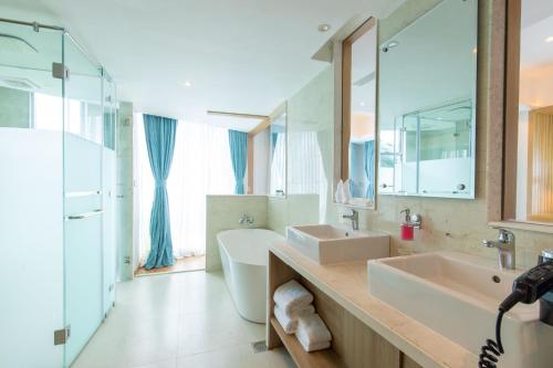奇旺Hotel Siraichuli的浴室设有2个水槽、浴缸和镜子