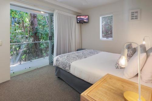 努萨角The Cove Noosa - Apartment 16的酒店客房设有一张床和一个大窗户