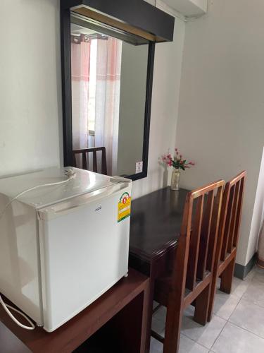曼谷Win Mansion的厨房配有桌子和白色冰箱。
