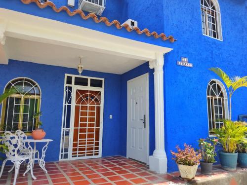 Catia La MarBELLA SUITE frente al Aeropuerto的蓝色的房子,设有白色的门和庭院