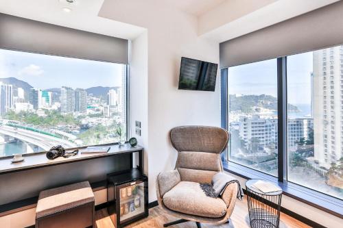 香港Urbanwood Ap Lei Chau的客厅配有椅子和大窗户