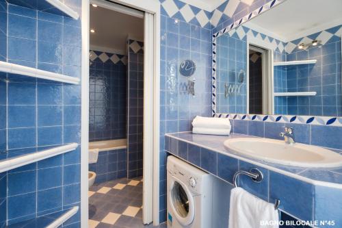 都灵Residence Sacchi Aparthotel的蓝色的浴室设有水槽和洗衣机。
