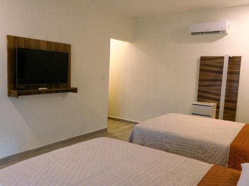 Isla AguadaHOTEL ISLA的客房设有两张床和一台平面电视。