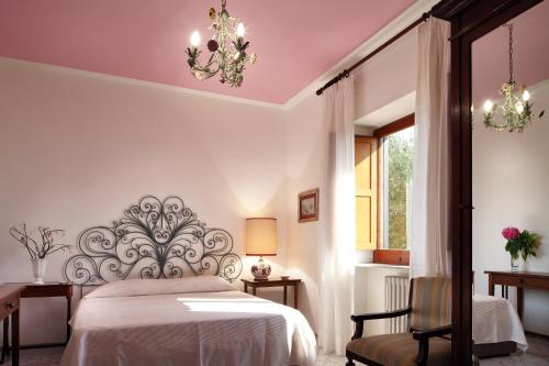 索伦托索伦托M套房酒店的卧室配有床、椅子和窗户。