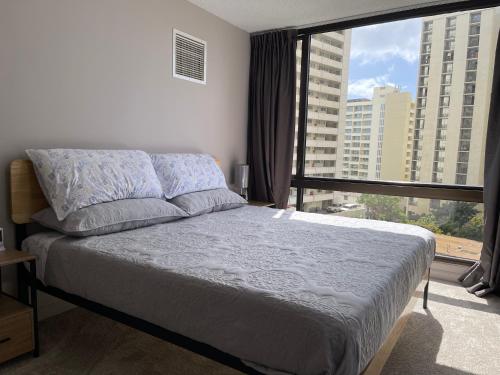 檀香山Waikiki Sunset的一间卧室设有一张床和一个大窗户