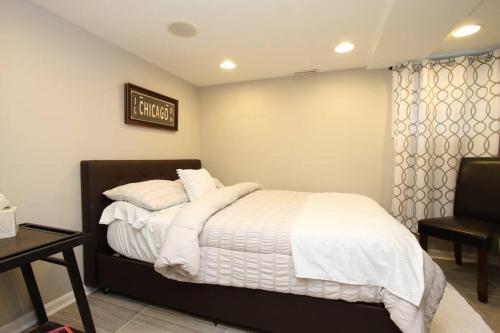 芝加哥15 min Ohare/Rivers Casino/Downtown & Parking1的一间卧室配有一张带白色毯子和枕头的床。