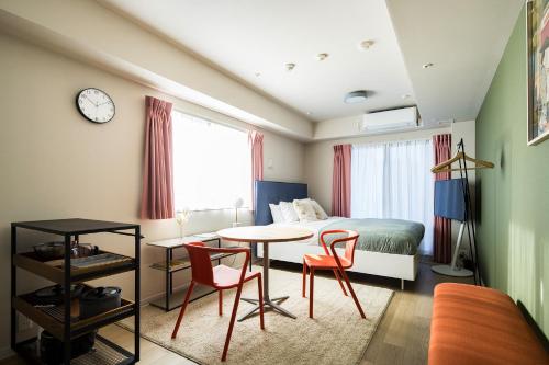 东京Section L Residence Ginza的卧室配有一张床和一张桌子及椅子