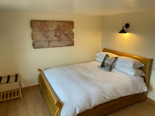 布拉克利Little Buttercup Cottage的一间卧室配有带白色床单和枕头的床。