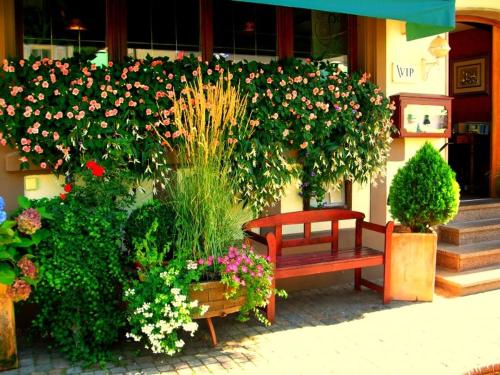 沃尔法赫克朗餐厅酒店的鲜花盛开的建筑前方的红色长凳