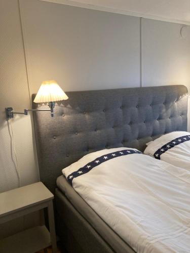 SkurupSlimmingegården的一间卧室配有一张带床头板和灯的床
