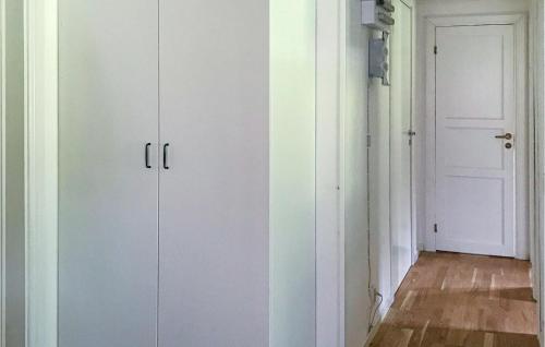 TrÃ¥ngsvikenLovely Home In Trngsviken With Kitchen的有一扇门的房间的两套白色橱柜