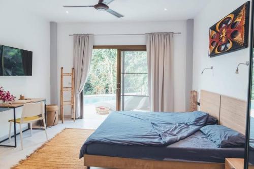 恰洛克拉姆MAGNIFICENT SOUL VILLA的一间卧室配有一张床、一张书桌和一个窗户。