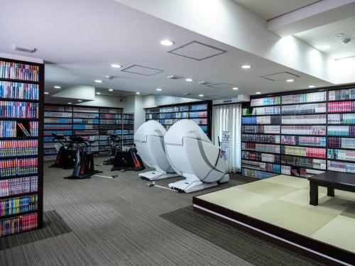 新泻新泻第一酒店的图书馆里放着两把椅子和许多书