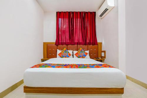 孟买FabExpress Diamond I的一间卧室配有一张带红色窗帘的大床