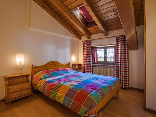 摩德纳迪-坎皮格里奥Residenza 3-Tre的一间卧室配有一张色彩缤纷的床和一扇窗户