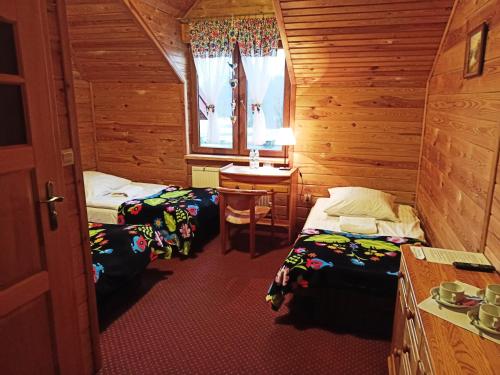 卢布林Malibu Lublin的客房设有两张床、一张桌子和一扇窗户。