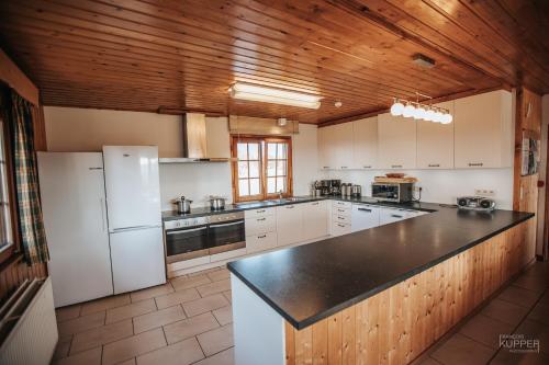 马尔梅迪Le Gagnage 31 pers- Malmedy, rustique, vue, wellness的一间厨房,配有白色家电和木制天花板