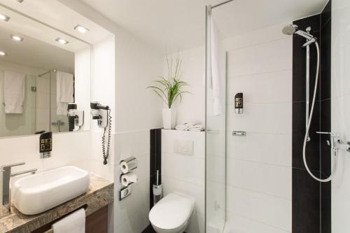美因河畔法兰克福总站酒店的带淋浴、卫生间和盥洗盆的浴室