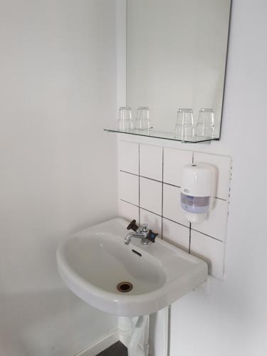 埃斯基尔斯蒂纳里拉旅馆的带玻璃杯的白色浴室内的白色水槽