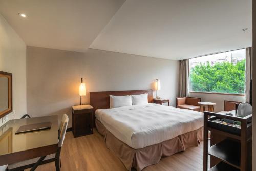 台北北投水美温泉会馆 的配有一张床、一张书桌和一扇窗户的酒店客房