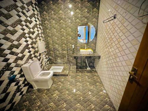 木尔坦The Signature Hotel Multan的一间带卫生间、水槽和镜子的浴室