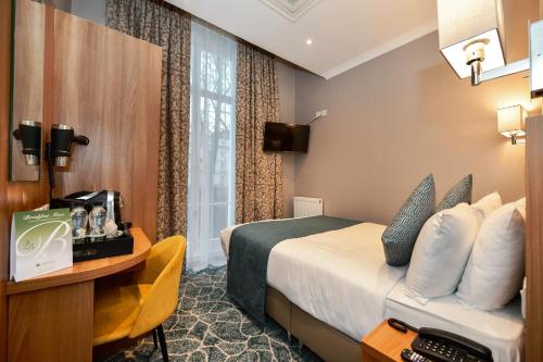 伦敦Park Avenue Bayswater Inn Hyde Park的配有一张床和一张书桌的酒店客房