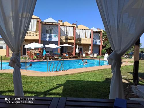 波塞蒂Ydna Apartments的享有游泳池与度假村的景色