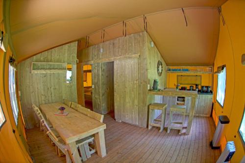 苏亚克Parc de vacances La Draille的房屋内带桌子和厨房的房间