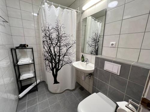 雷克雅未克Panoramic Studio Apartment with stunning view - Free Parking的浴室设有淋浴帘,上面有一棵树