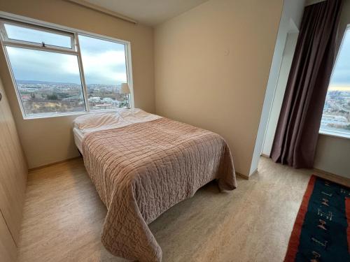 雷克雅未克Panoramic Studio Apartment with stunning view - Free Parking的一间卧室设有一张床和一个大窗户