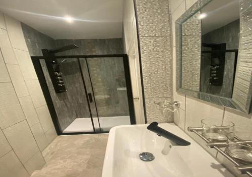 布莱克浦亚历山大酒店的白色的浴室设有水槽和镜子