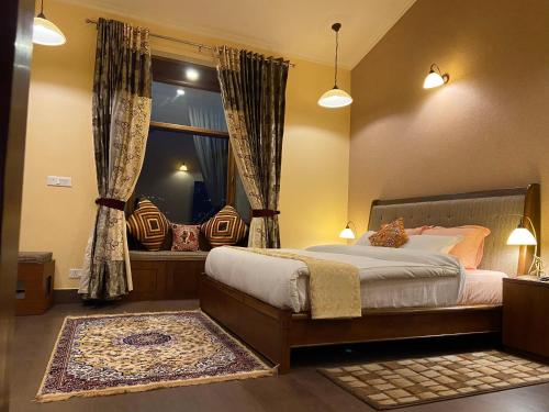 奈尼塔尔Sangita Resorts的一间卧室设有一张大床和一个窗户。