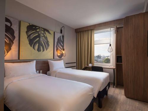 圣克鲁斯ibis Santa Cruz de la Sierra的酒店客房设有两张床和窗户。