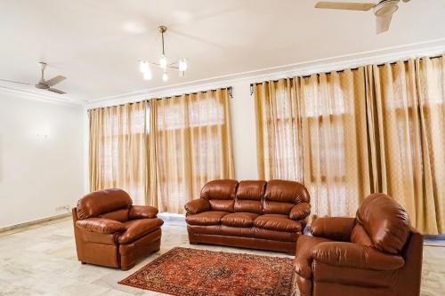 新德里FabExpress Goodwill Homes的客厅配有两把椅子和一张沙发