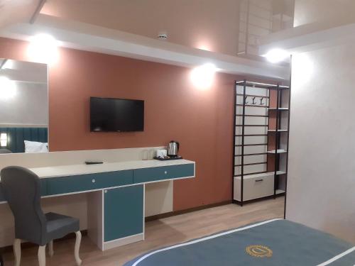 祖格迪迪DADIANI Inn的客房设有书桌和墙上的电视