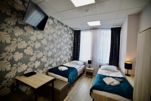 琴斯托霍瓦Hostel OPEN GARDEN的一间酒店客房,设有两张床和电视