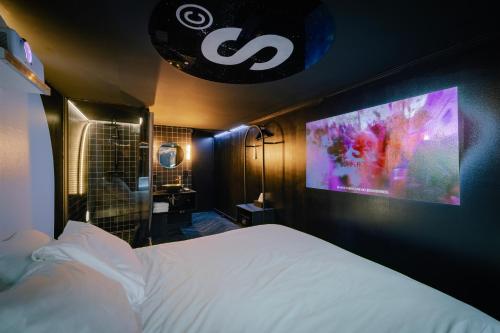 阿姆斯特丹SUPPER Hotel的卧室配有一张床,墙上配有电视。