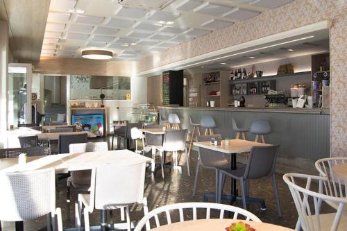 维拉波圣路易酒店的一间带桌椅的餐厅和一间酒吧