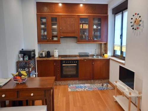 希洪MenVal16的厨房配有木制橱柜和木桌。