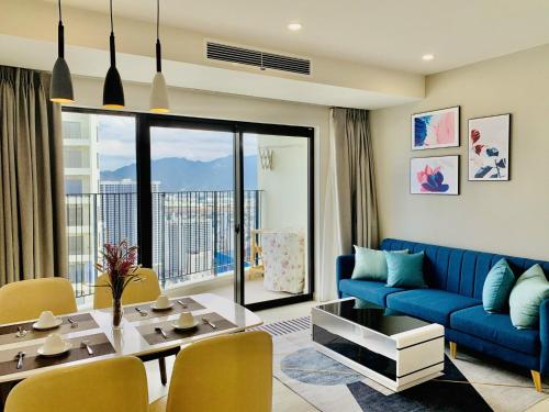 芽庄Gold Coast Luxury Apartment Nha Trang的客厅配有蓝色的沙发和桌子