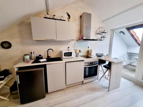 昂古莱姆Centre ville, T2 tout confort lumineux et calme !的小厨房配有白色橱柜和桌子