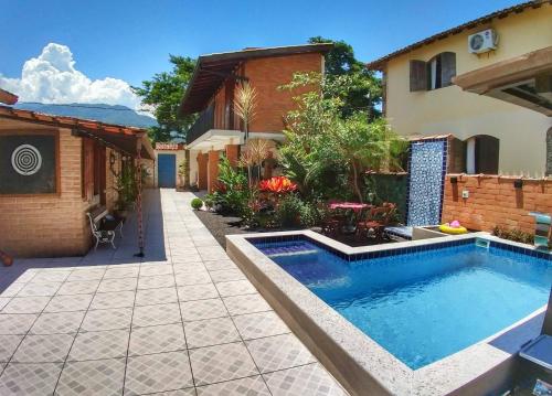 帕拉蒂Portal Sui­tes Casa do Lago的一座房子旁的院子内的游泳池