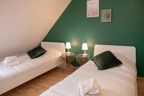 阿格诺Maison - Le Terra Verde - Terrasse的两张白色的床,位于带绿色墙壁的房间
