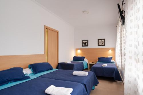 帕特纳米特帕特纳旅馆的一间设有两张蓝色床单的床的房间